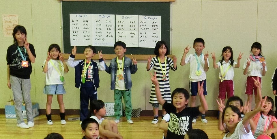 写真:折り紙のメダルをもらってにっこり♪