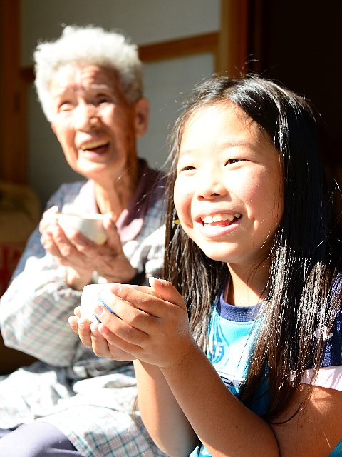写真:縁側で白川茶を愉しむおばあさんと子ども