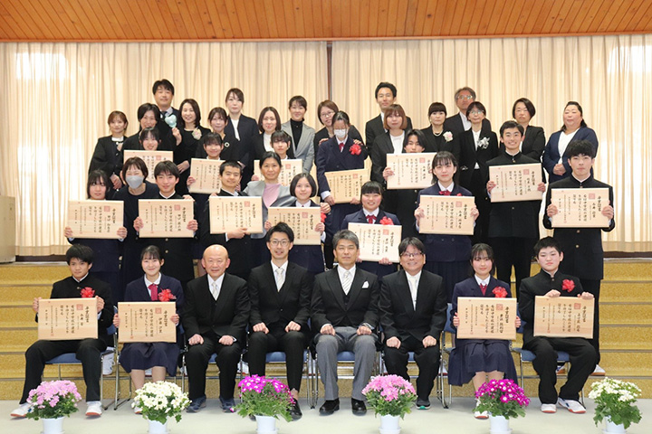 写真:卒業証書を手に保護者の皆様、先生方と記念撮影